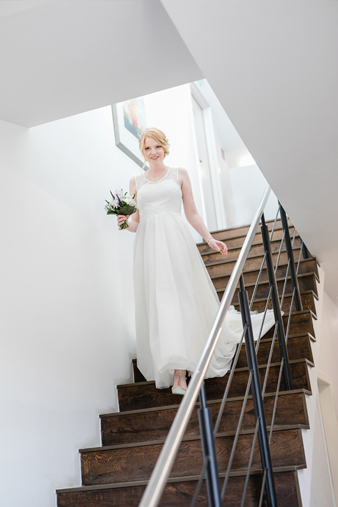 Die Braut auf der Treppe auf dem Gut Hohenholz auf dem Weg zum First Look mit dem Bräutigam - Fotografin: Sonja Yasmin Fotografie, Hochzeitsfotografin in Köln, Bonn und ganz NRW, Fotografin für Portraitfotos und Familienfotos