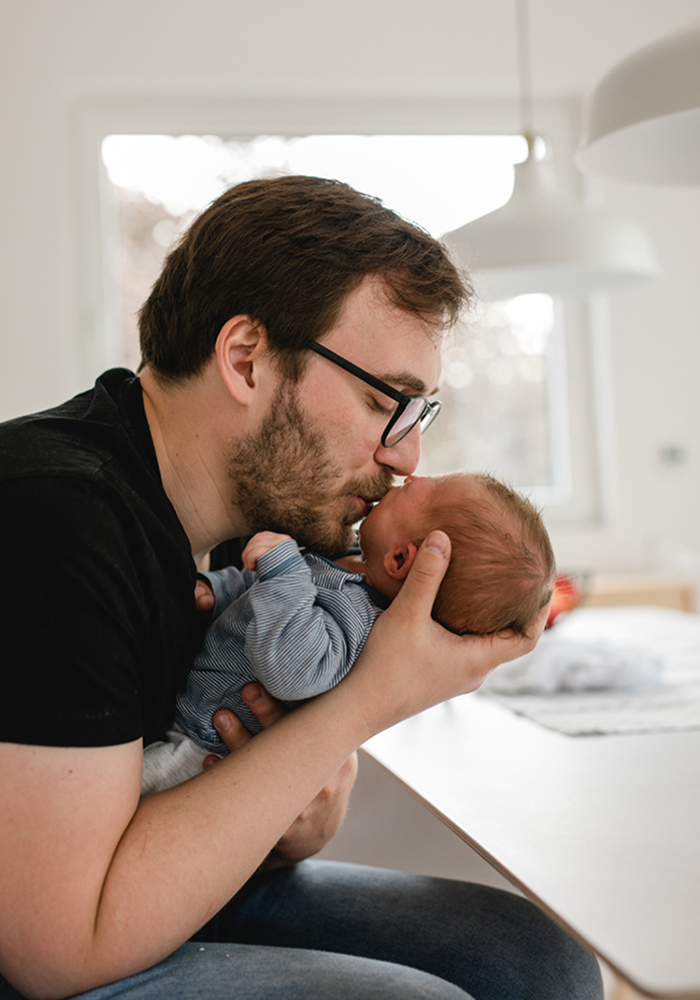 Der Papa küsst sein Baby beim Familienshooting zu Hause - Fotografin: Sonja Yasmin Fotografie, Hochzeitsfotografin in Köln, Bonn und ganz NRW, Fotografin für Portraitfotos und Familienfotos