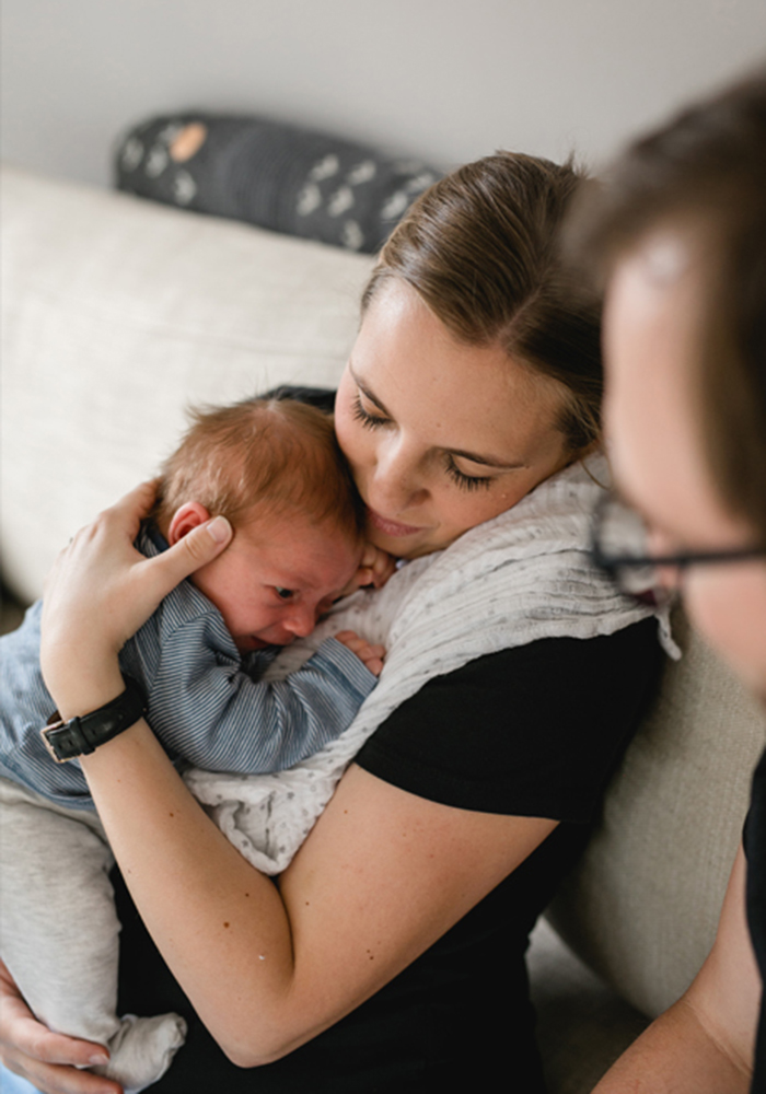 Die Mama kuschelt mit ihrem Baby während des Familienshootings zu Hause - Fotografin: Sonja Yasmin Fotografie, Hochzeitsfotografin in Köln, Bonn und ganz NRW, Fotografin für Portraitfotos und Familienfotos
