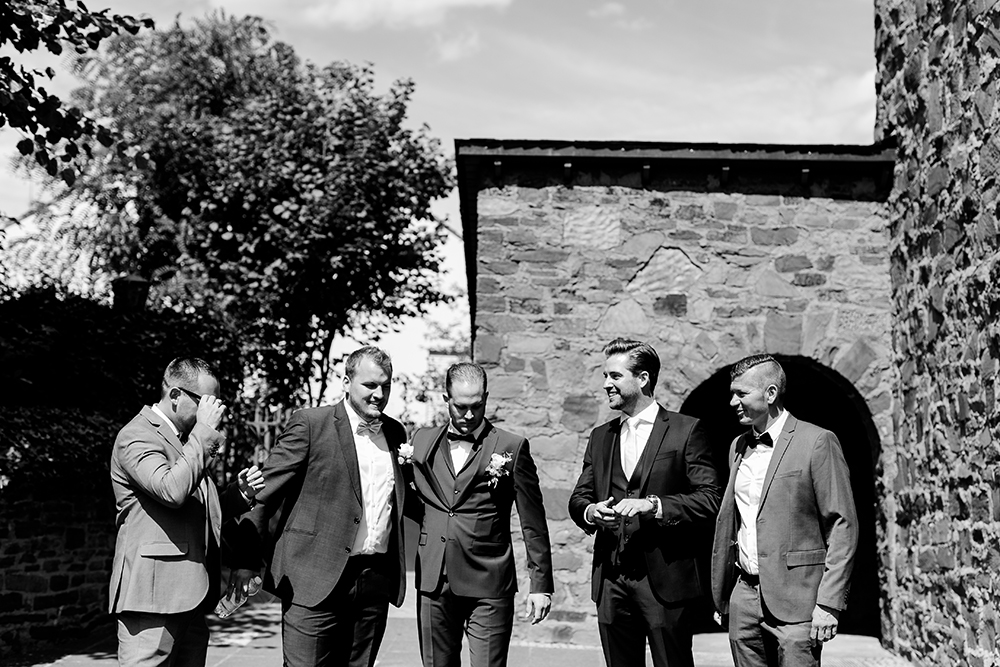 Freunde und Trauzeuge mit Bräutigam vor der Kirche - Fotografin: Sonja Yasmin Fotografie, Hochzeitsfotografin in Köln, Bonn und ganz NRW, Fotografin für Portraitfotos und Familienfotos