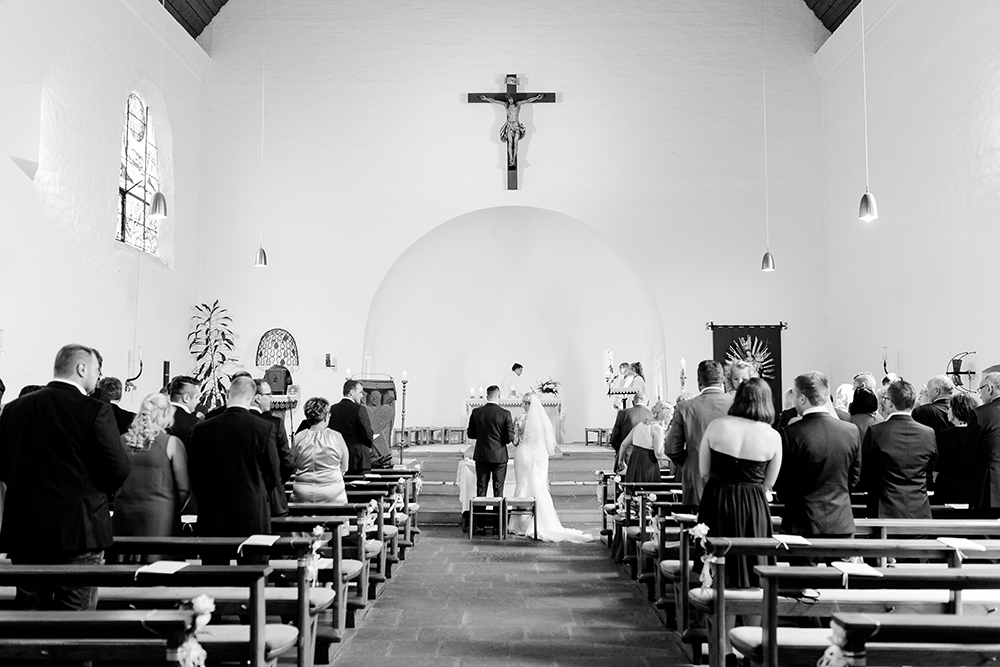 Gesamtaufnahme der Kirche in schwarzweiß während der Trauung - Fotografin: Sonja Yasmin Fotografie, Hochzeitsfotografin in Köln, Bonn und ganz NRW, Fotografin für Portraitfotos und Familienfotos