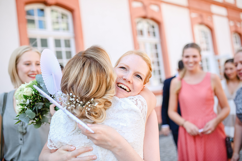 Braut wird umarmt und beglückwünscht nach der standesamtlichen Trauung in der Abtei Brauweiler - Fotografin: Sonja Yasmin Fotografie, Hochzeitsfotografin in Köln, Bonn und ganz NRW, Fotografin für Portraitfotos