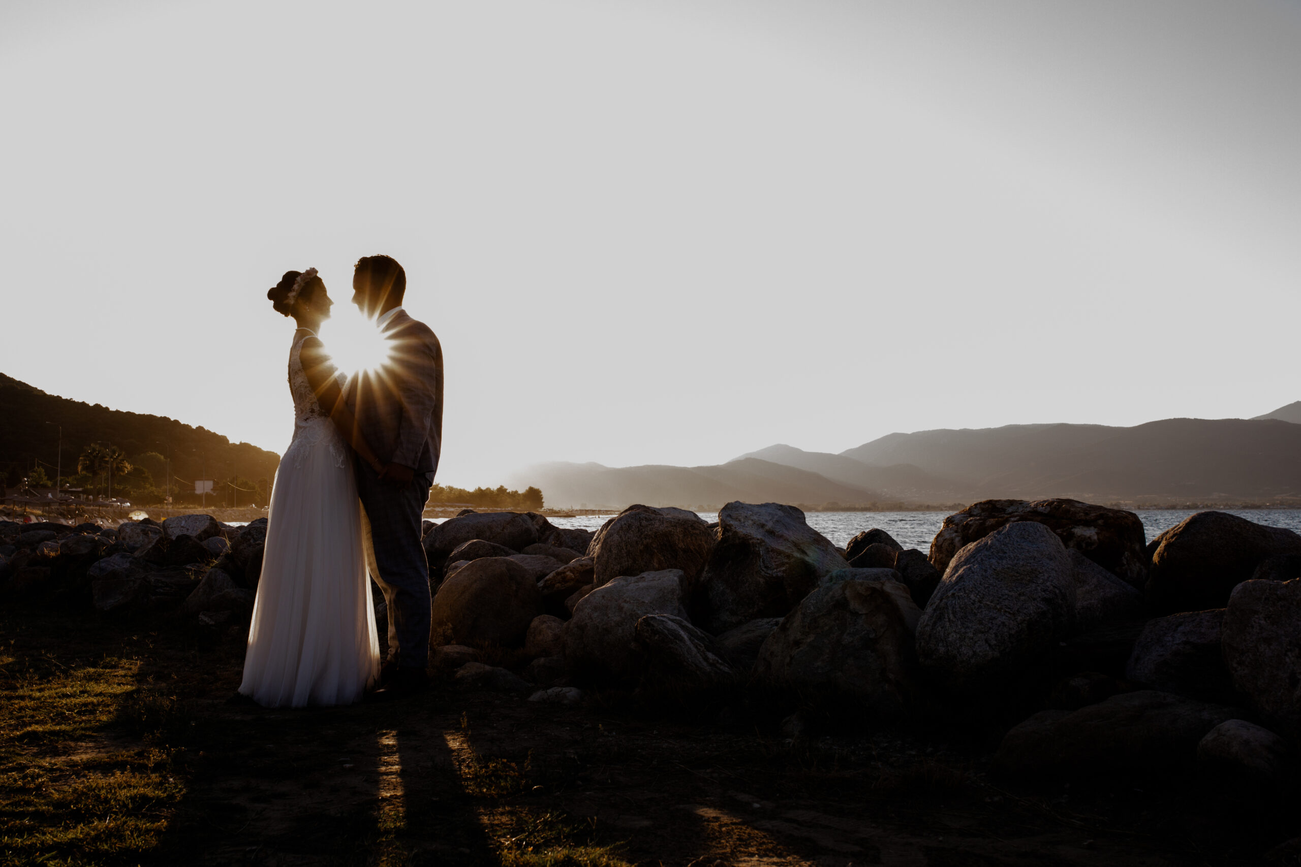 Das Brautpaar stand zum Sonnenuntergang romantisch zusammen am Meer. Die Destinationwedding fand in Griechenland statt - Fotografin: Sonja Yasmin Fotografie, Hochzeitsfotografin in Köln, Bonn und ganz NRW, Fotografin für Portraitfotos